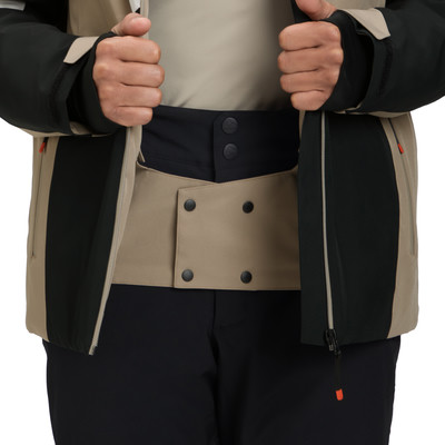 Detail einer Skijacke mit beige Schneefang und schwarzen Druckknöpfen.