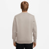 Rückansicht eines Mannes in einem beigefarbenen Sweatshirt vor weißem Hintergrund.