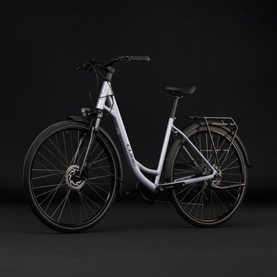 Silbernes Cube Citybike mit Licht und Gepäckträger vor schwarzem Hintergrund.