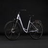 Silbernes Cube Citybike mit Licht und Gepäckträger vor schwarzem Hintergrund.