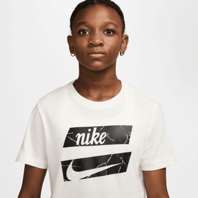 Mädchen im weißen Nike-T-Shirt, weißer Hintergrund. Mädchen im weißen Nike-T-Shirt, weißer Hintergrund.