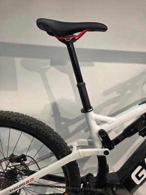 Ein Teil eines Mountainbikes mit weißem Rahmen und schwarzem Sattel. Ein Teil eines Mountainbikes mit weißem Rahmen und schwarzem Sattel.