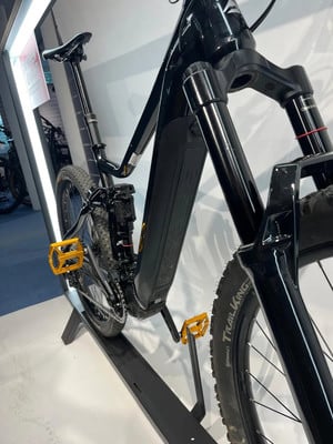 Schwarzes E-Bike mit gelben Pedalen auf einem Ständer. Schwarzes E-Bike mit gelben Pedalen auf einem Ständer.