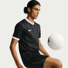 Ein Mann im schwarzen Nike-Trikot mit weißem Kragen und Ärmeln spielt mit einem Ball.