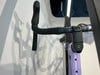 Detail von Lenker und Vorbau eines Fahrrads mit violettem Rahmen.