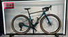 Ein blaues Ridley Gravelbike mit beige Reifen und goldenen Akzenten.
