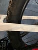 Rahmendetail eines weißen Fahrrads mit Reifenteil und Speichen.