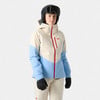 Frau in einer beige-blauen Skijacke mit rotem Reißverschluss und Helm.