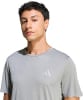 Mann in einem grauen T-Shirt mit Adidas-Logo auf der Brust.