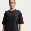 Eine Frau in einem schwarzen Kurzarmshirt mit Rundhalsausschnitt.