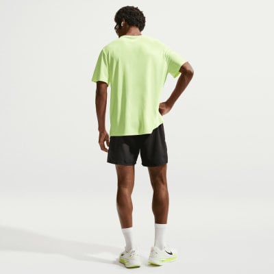 Ein Mann in einem neongrünen T-Shirt und schwarzer Hose steht von hinten. Ein Mann in einem neongrünen T-Shirt und schwarzer Hose steht von hinten.