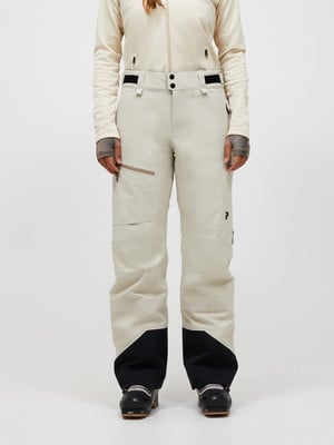 Damen-Skihose in Beige mit schwarzem Saum und Skischuhen. Damen-Skihose in Beige mit schwarzem Saum und Skischuhen.