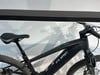 Ein schwarzes Cube Reaction E-Mountainbike mit Federung und breiten Reifen.