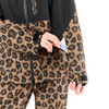 Eine Person in einer Leopardenjacke steckt eine Karte in eine Ärmeltasche.