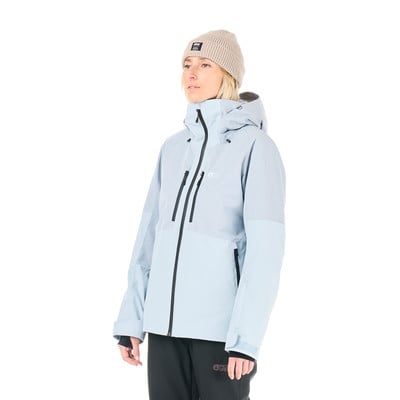 Eine Frau in einer Skijacke und Mütze posiert vor weißem Hintergrund. Eine Frau in einer Skijacke und Mütze posiert vor weißem Hintergrund.