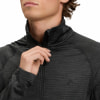 Detail eines Mannes, der einen dunklen Pullover mit Stehkragen und Logo schließt.