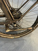 Detail eines Fahrradhinterrads mit Scheibenbremse und Ständer.