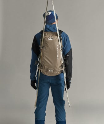 Rückansicht eines Skifahrers mit Rucksack und am Rücken befestigten Skiern. Rückansicht eines Skifahrers mit Rucksack und am Rücken befestigten Skiern.