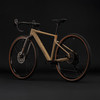 Beige Cube Gravelbike mit braunen Reifen auf schwarzem Hintergrund.