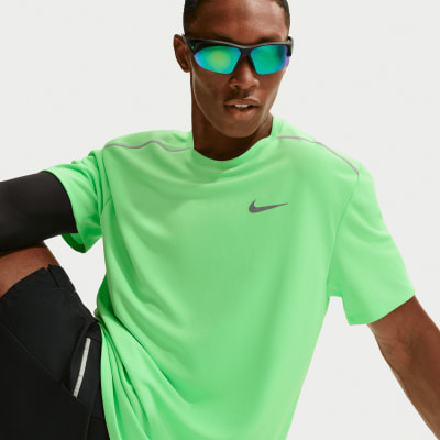 Ein Mann im grünen Nike-Shirt und Sonnenbrille sitzt.