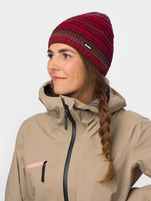 Eine Frau mit Zopf und Strickmütze trägt eine beige Jacke. Eine Frau mit Zopf und Strickmütze trägt eine beige Jacke.