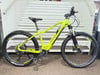 Ein grünes Genesis E-Bike mit Federung und Scheibenbremsen steht auf einer Treppe.