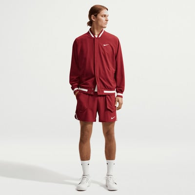 Ein Mann in roter Nike-Kleidung mit Logo auf Jacke und Shorts. Ein Mann in roter Nike-Kleidung mit Logo auf Jacke und Shorts.