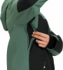 Ein Mann öffnet eine grüne Jacke mit schwarzen Einsätzen und enthüllt ein Mesh-Futter.