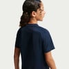 Mädchen mit dunklen lockigen Haaren und Spangen in einem dunkelblauen Shirt.