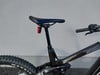 Sattel und Dämpfer eines Mountainbikes mit schwarzem Rahmen.