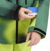 Eine Hand steckt eine Karte in eine Jackentasche mit buntem Muster.