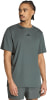 Ein Mann in einem dunkelgrünen Adidas T-Shirt mit kurzen Ärmeln und Shorts.