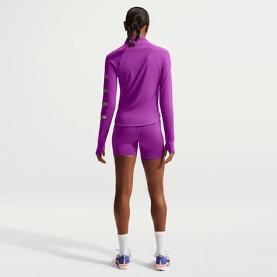 Eine Frau in violetter Sportkleidung steht mit dem Rücken zur Kamera. Eine Frau in violetter Sportkleidung steht mit dem Rücken zur Kamera.
