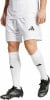 Ein Mann in weißem Fußballtrikot und Shorts mit schwarzen Fußballschuhen.