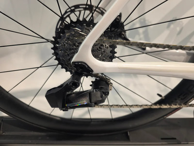 Detail des hinteren Schaltwerks und der Kassette auf einem weißen Fahrrad. Detail des hinteren Schaltwerks und der Kassette auf einem weißen Fahrrad.