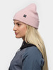 Eine Frau in einer rosa Mütze und einer blauen Jacke, Seitenansicht.