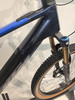 Detail des Rahmens eines dunkelblauen Mountainbikes mit blauem Streifen.