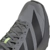 Grauer Laufschuh mit dunklen Streifen und grünen Schnürsenkeldetails.
