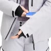 Eine Frau steckt eine Karte in die Ärmeltasche einer Skijacke.