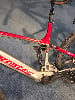 Detail eines Mountainbike-E-Bikes mit rotem Rahmen und Dämpfer.