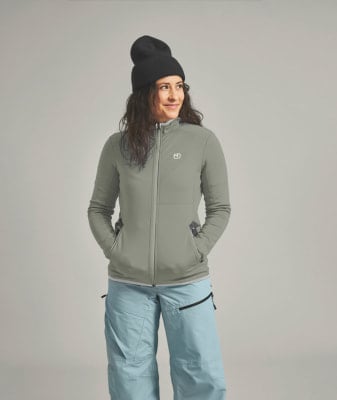 Eine Frau in einer grauen Jacke und hellblauen Skihose mit schwarzer Mütze. Eine Frau in einer grauen Jacke und hellblauen Skihose mit schwarzer Mütze.