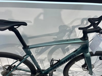 Grünes Specialized Rennrad mit tropfenförmigem Rahmen und schwarzem Sattel.