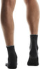 Rückansicht von Waden und Knöcheln eines Mannes in schwarzen Socken.