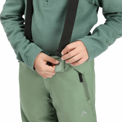 Kind befestigt Hosenträger an Hose, Nahaufnahme. Kind befestigt Hosenträger an Hose, Nahaufnahme.