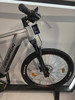 Detail eines Genesis Mountain-E-Bikes mit Federung und Scheibenbremse.