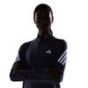Nő sötét, hosszú ujjú pólóban Adidas logóval.