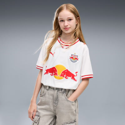 Mädchen in weißem T-Shirt mit Red Bull Logo und zwei Bullen, graue Hose.