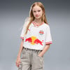 Mädchen in weißem T-Shirt mit Red Bull Logo und zwei Bullen, graue Hose.