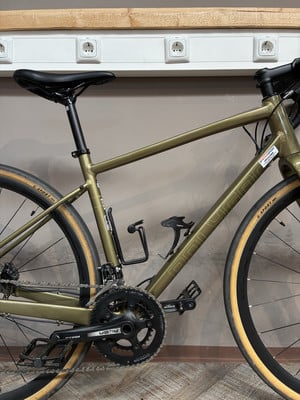 Ein goldenes Fahrrad mit schwarzem Sattel und schwarzen Pedalen steht an der Wand. Ein goldenes Fahrrad mit schwarzem Sattel und schwarzen Pedalen steht an der Wand.