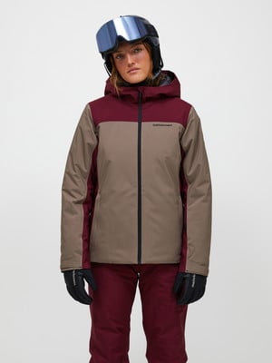 Eine Skifahrerin in einer bunten Jacke und einem Helm mit Brille posiert vor weißem Hintergrund. Eine Skifahrerin in einer bunten Jacke und einem Helm mit Brille posiert vor weißem Hintergrund.